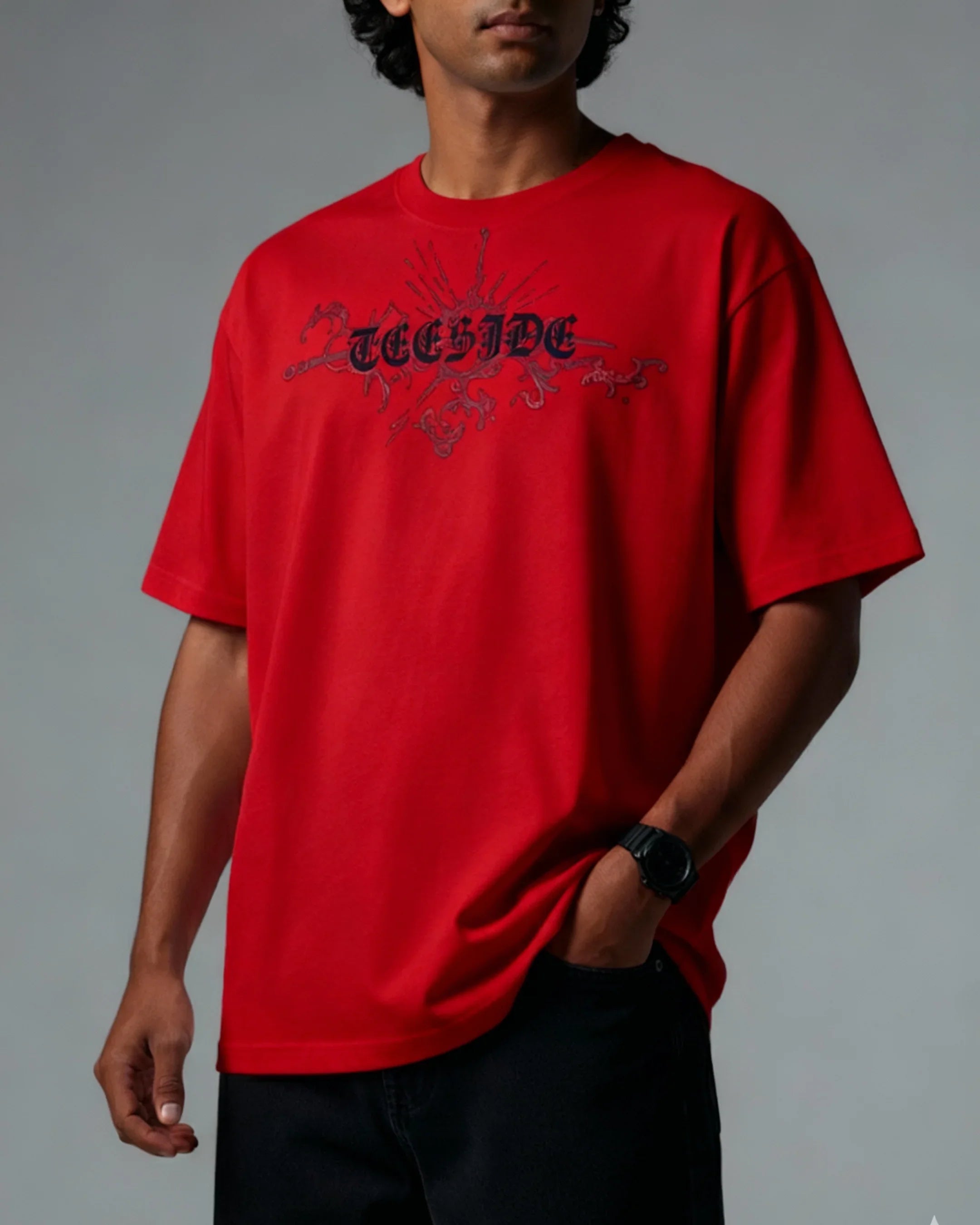 Man wearing red teeside graphic t-shirt with gothic font and ornamental design.