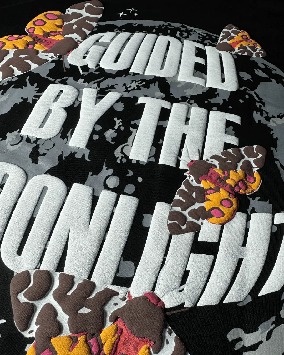 teeside shirt with embroidered moths and 'Guided by the Moonlight' text on black fabric