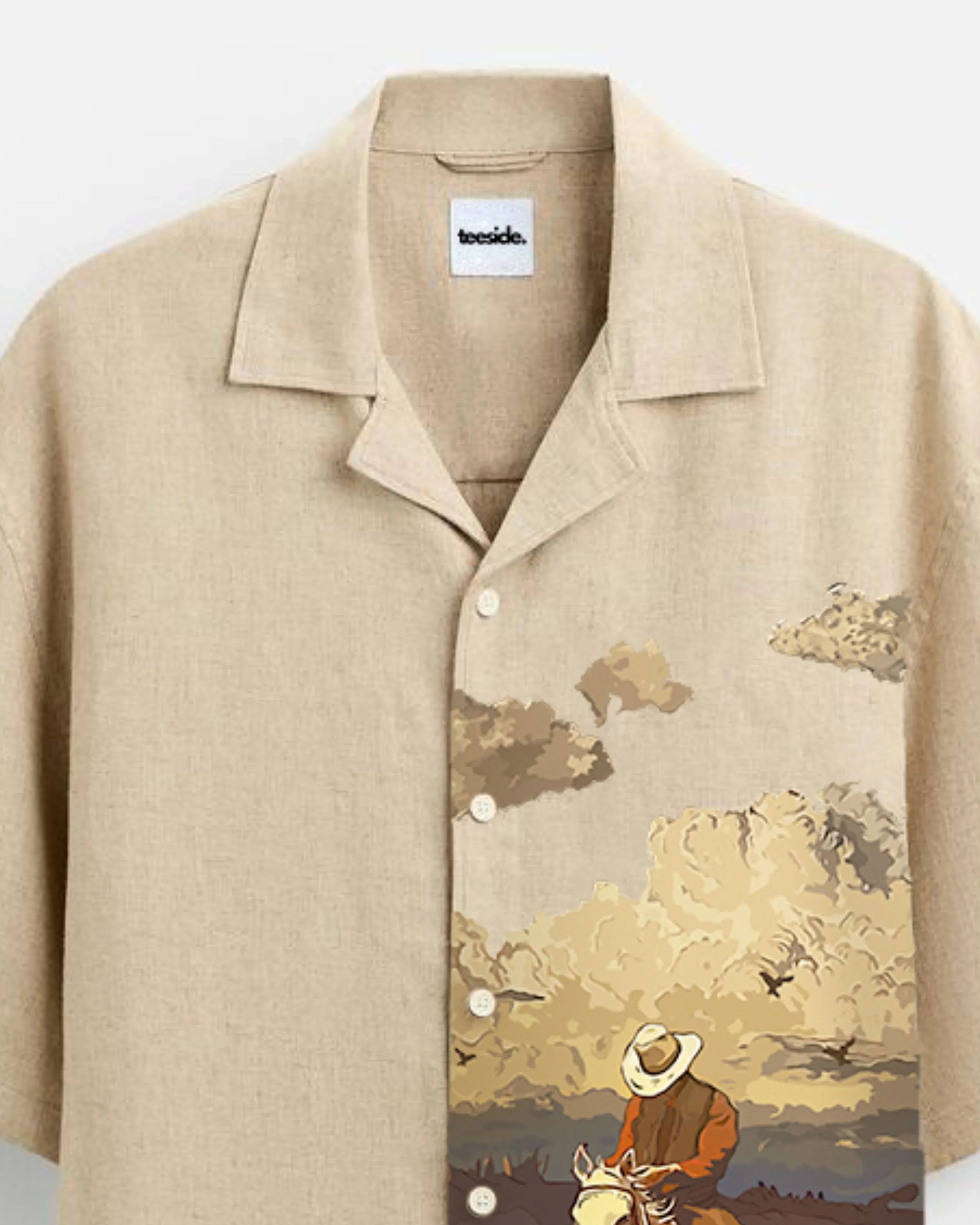 teeside beige shirt with cowboy and horse graphic, western style clouds and button-up design