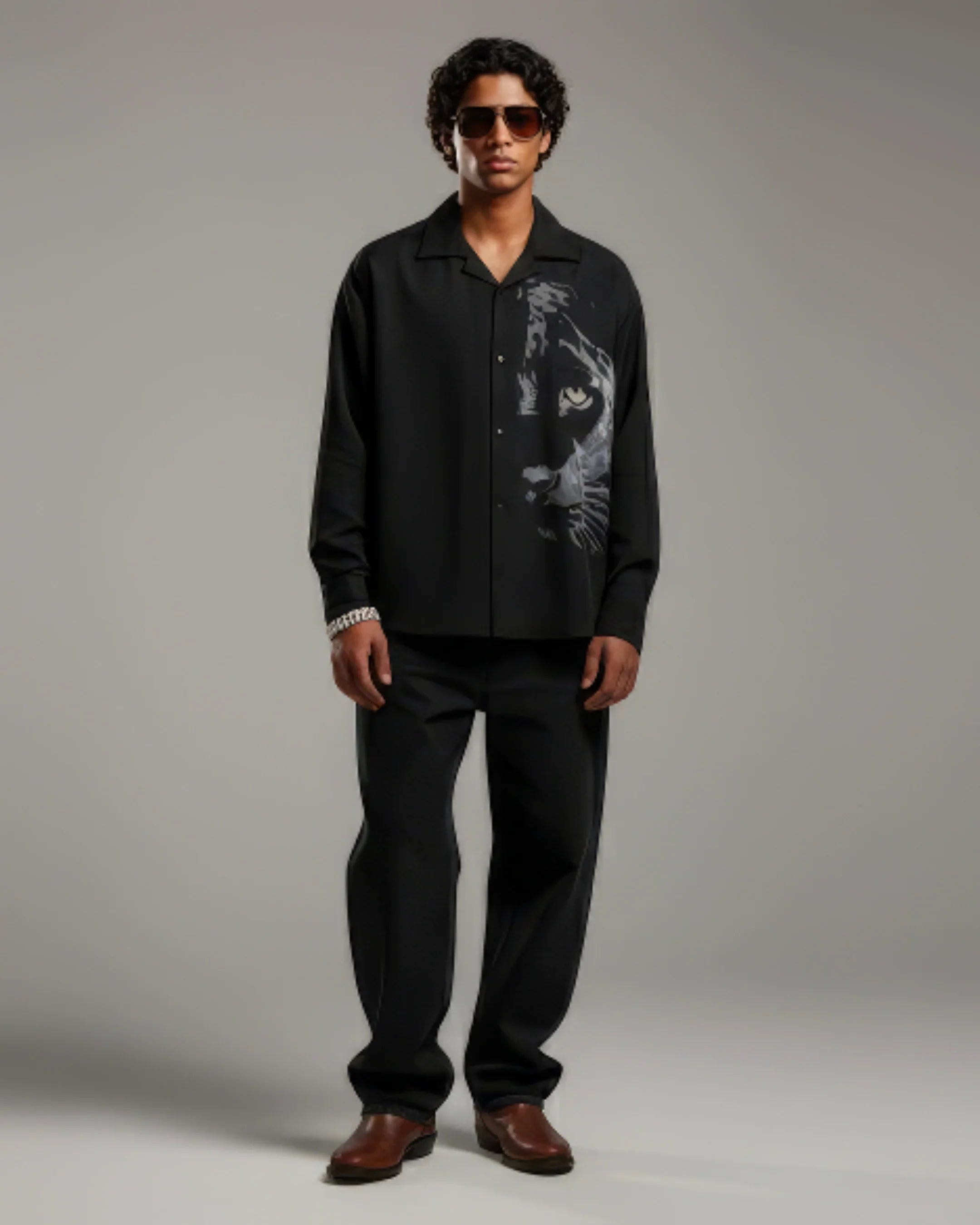 teeside men’s black shirt with panther graphic, black trousers, brown shoes, and sunglasses