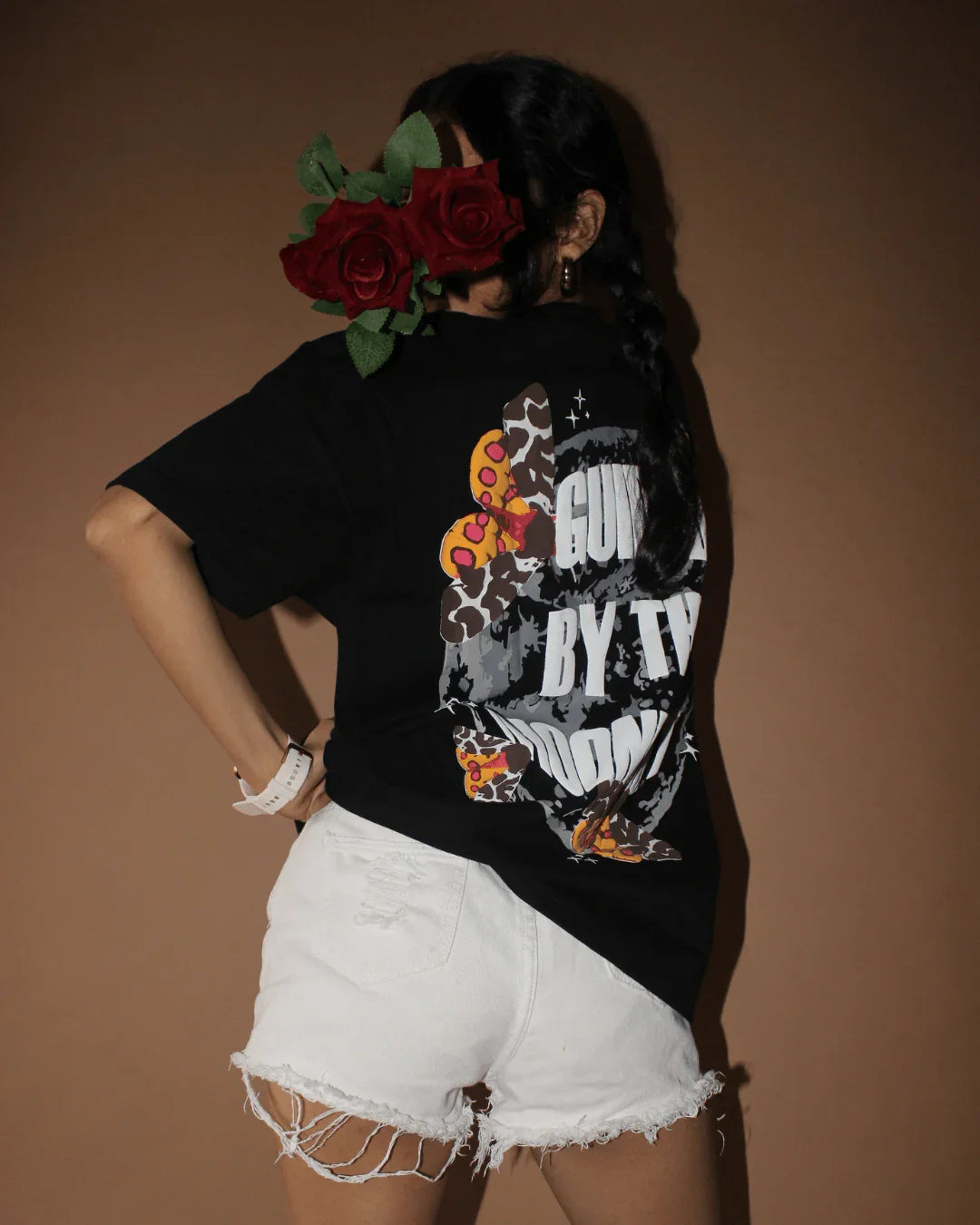 Teeside graphic black t-shirt and white distressed shorts, model with roses covering face