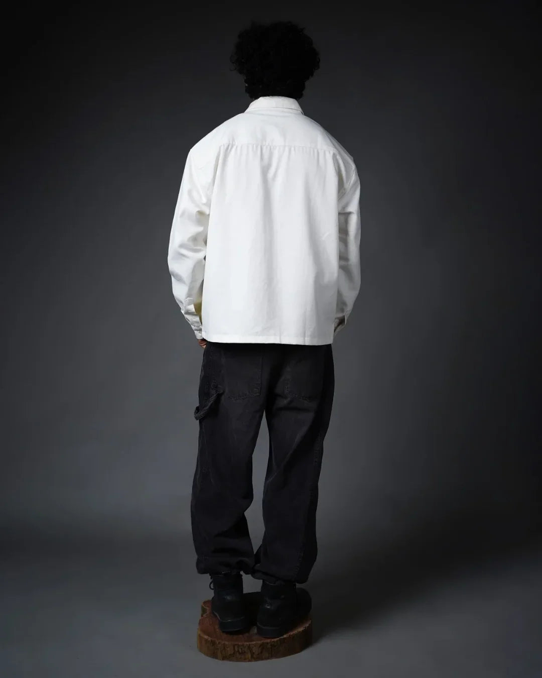 Back view of model in white long-sleeve shirt and black pants, teeside fashion style